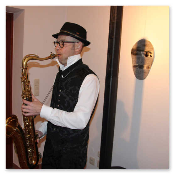 Ausstellung im Kunsthaus in Weiz. Skulpturen, Masken und Köpfe aus Keramik und Masken aus Glas. Gäste bei der Vernisage.